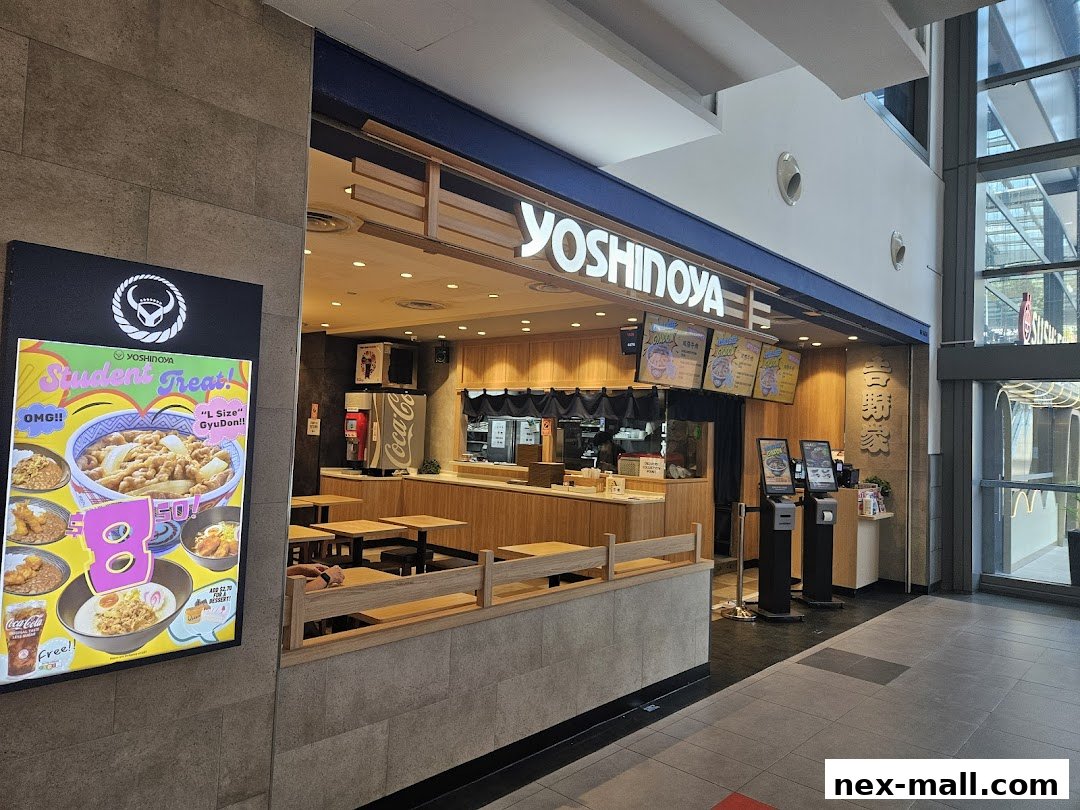The exterior of a Yoshinoya restaurant with a prominent sign and display advertising student treats.