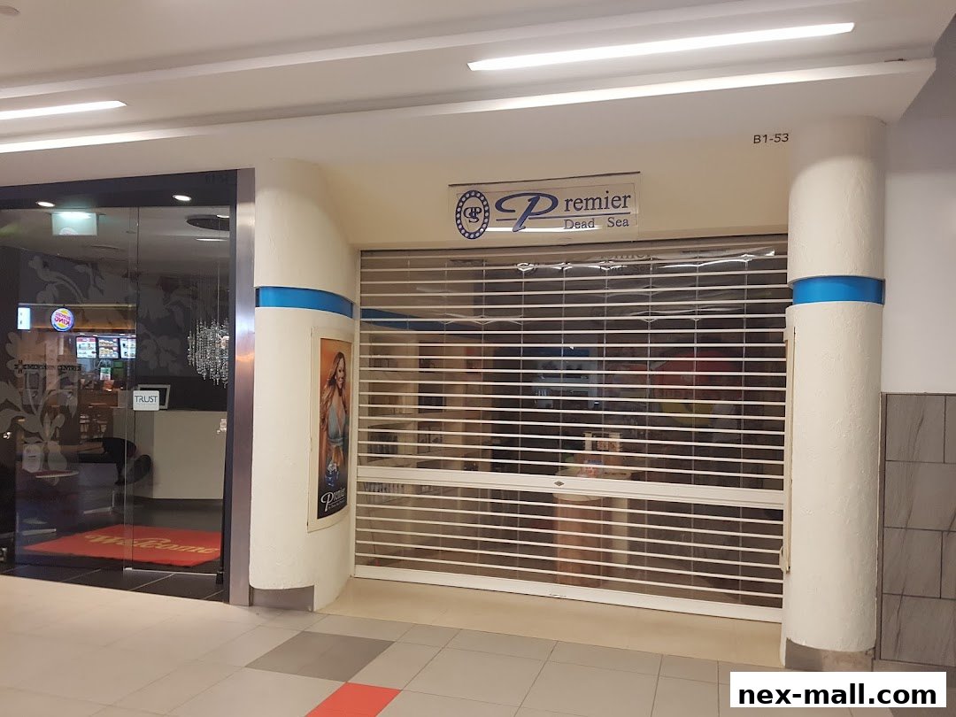 The closed Premier Dead Sea NEX shop with a roller shutter and a poster.