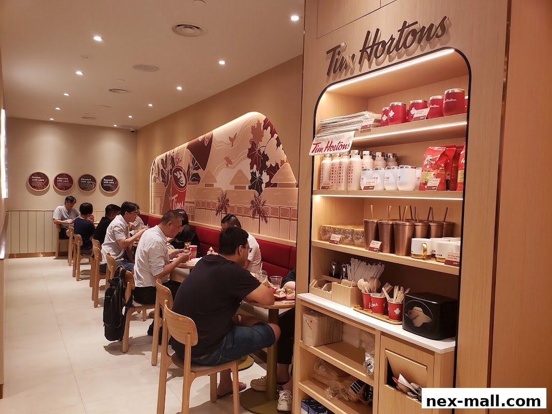 Interior of a Tim Hortons cafe with customers dining and merchandise displayed on shelves.