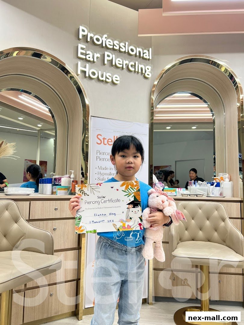 A child holds a piercing certificate and a stuffed bunny in a professional ear piercing studio.