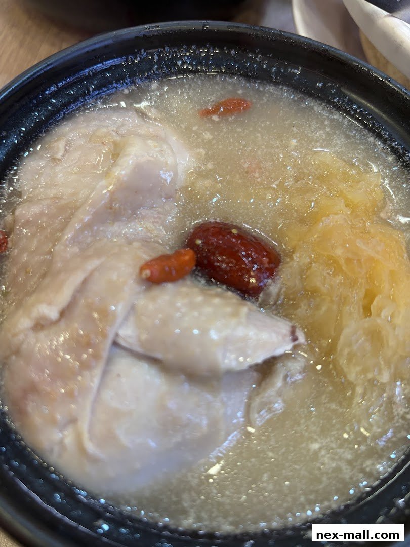 A close-up shot of a nourishing chicken soup with goji berries and other ingredients.