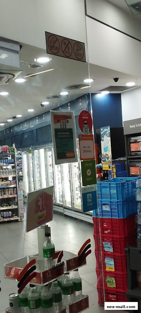 Interior view of a 7-Eleven store with refrigerators, promotional signs, and merchandise displays.