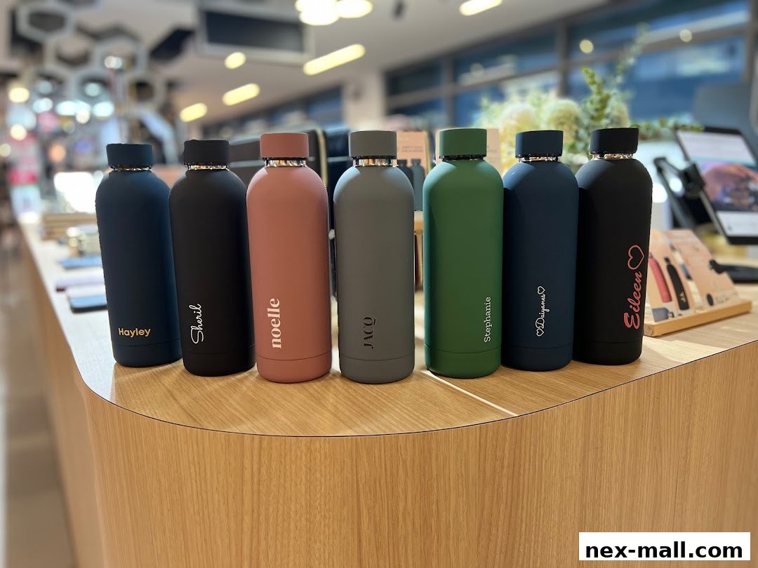 A row of personalized water bottles with names etched on them displayed on a wooden counter.