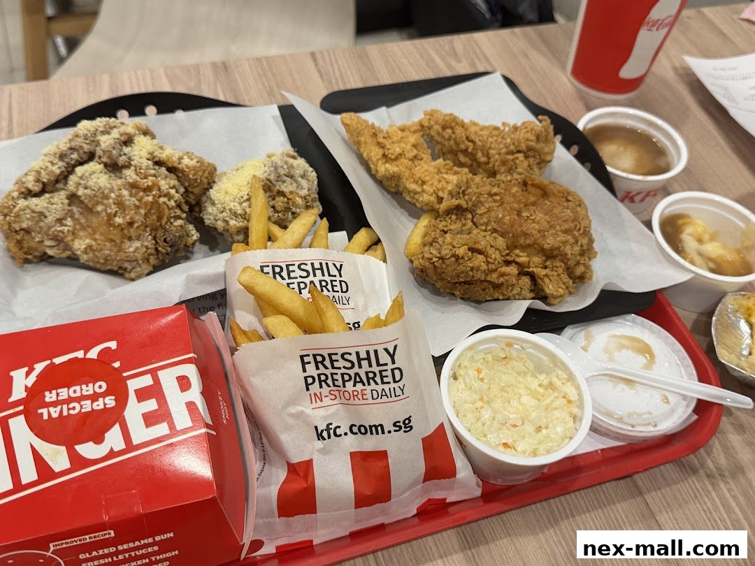A tray of KFC fried chicken, fries, coleslaw, mashed potatoes, and a drink.