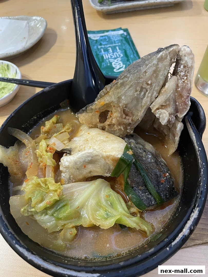 A close-up of a steaming bowl of Japanese fish soup with cabbage and fried fish pieces.