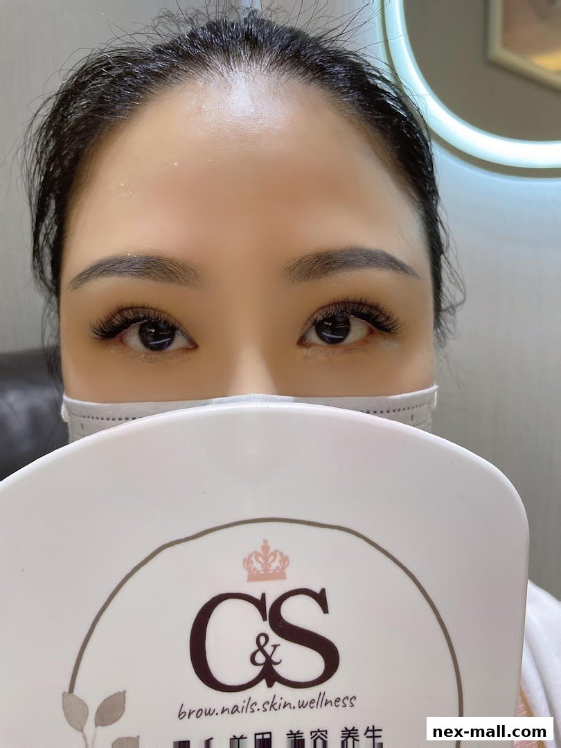 A close-up of a woman's eyes with dramatic false eyelashes and perfectly shaped eyebrows.