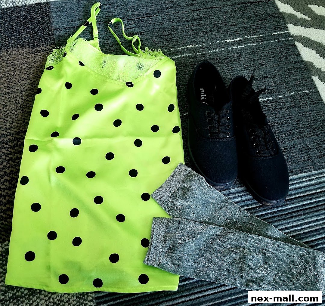 A neon green polka dot slip dress with black sneakers and silver patterned leg warmers.