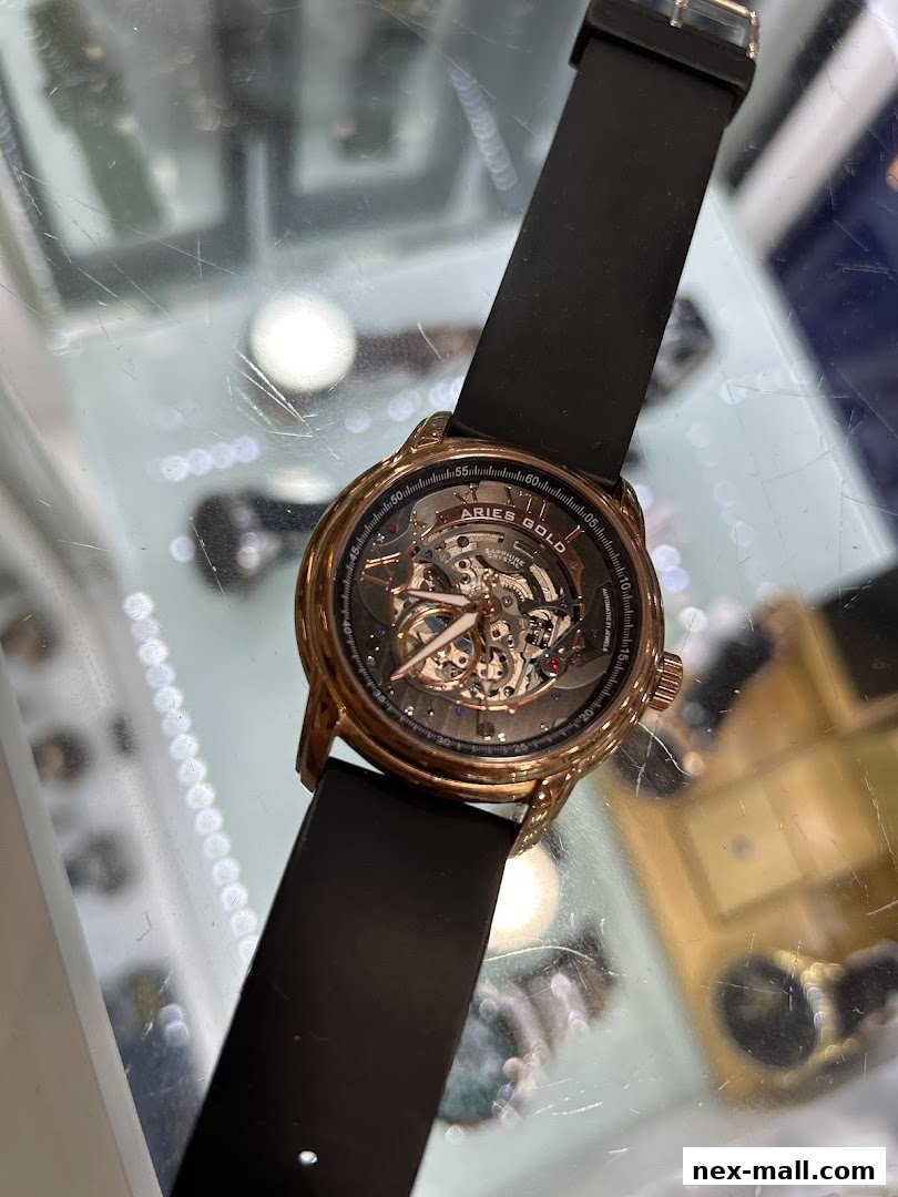 A close-up shot of a rose gold Aries Gold skeleton watch with a black strap.