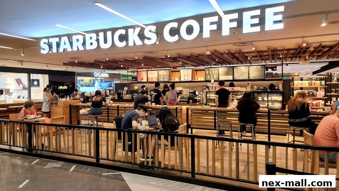 People are seated and ordering at a busy Starbucks coffee shop.
