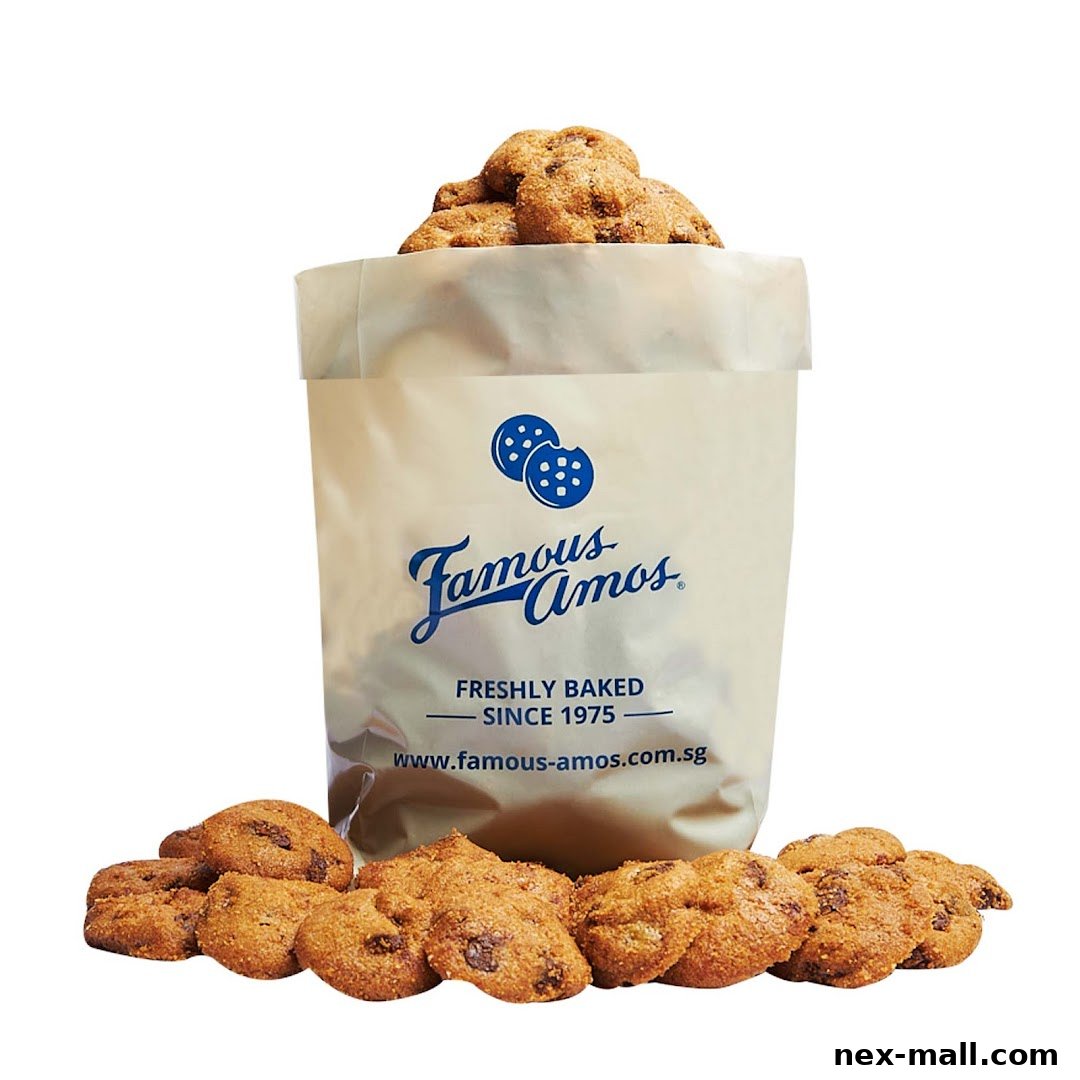 A bag filled with Famous Amos cookies, with more cookies scattered around.