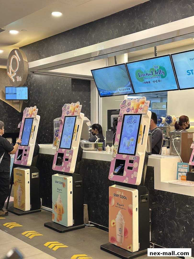KOI Thé shop with self-order kiosks and digital menu screens displaying drinks.