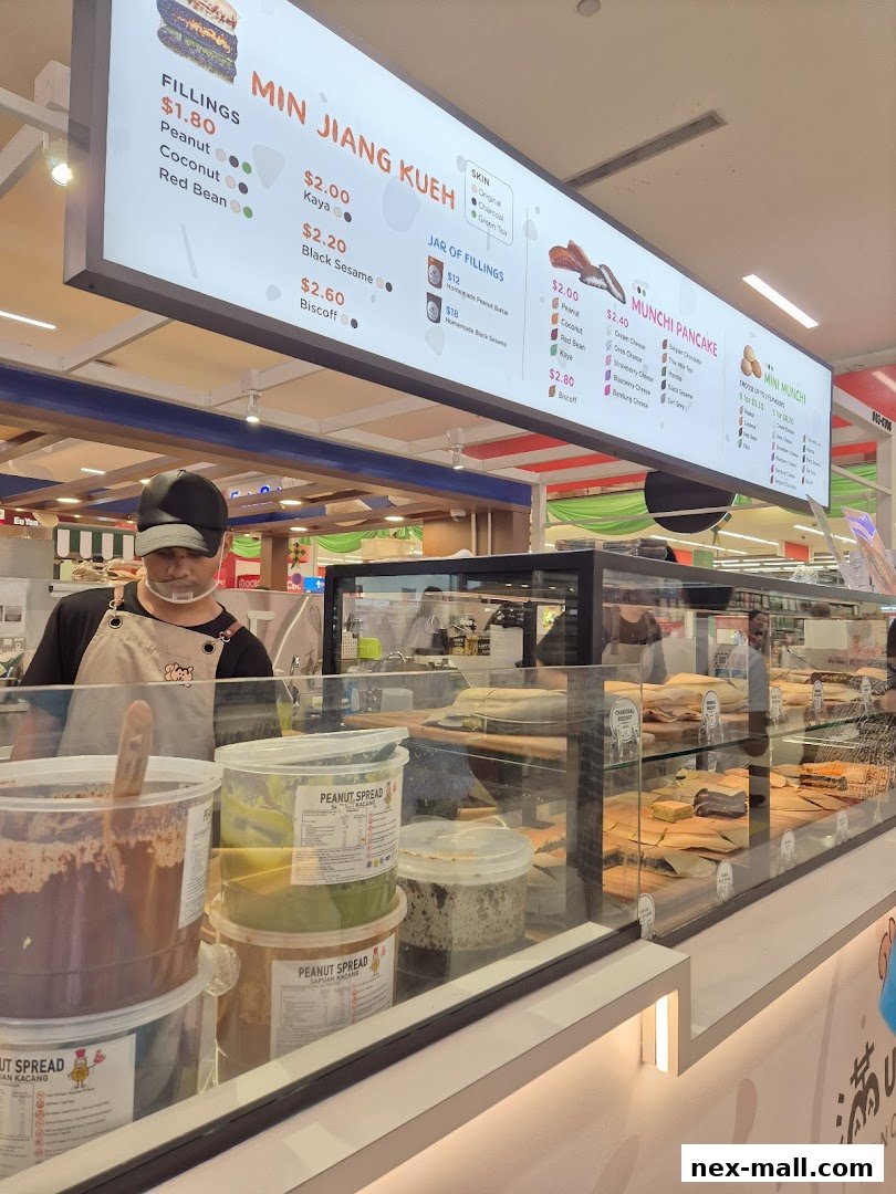 A brightly lit menu board displaying various pancake fillings and prices at Munchi Pancakes.