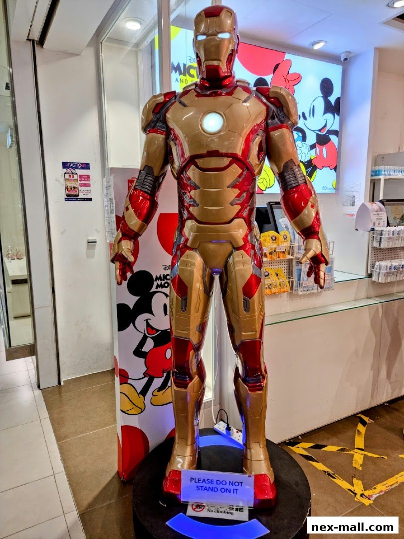 An Iron Man statue is displayed in a shop with Mickey Mouse branding in the background.