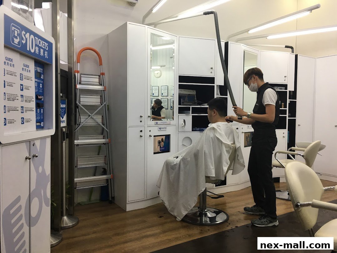 A barber is cutting a customer's hair in a modern salon with white cabinets and chairs.