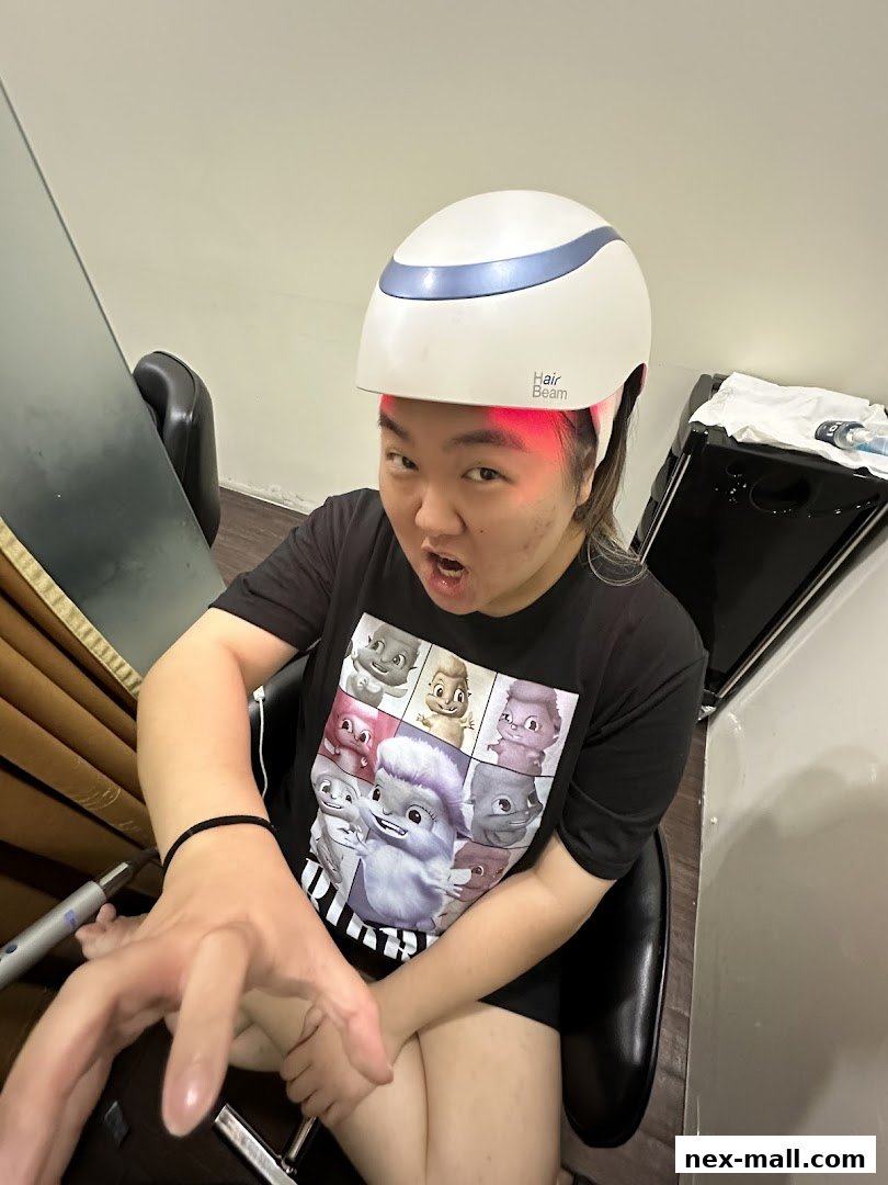 A person wearing a hair growth helmet with red lights and a graphic t-shirt.