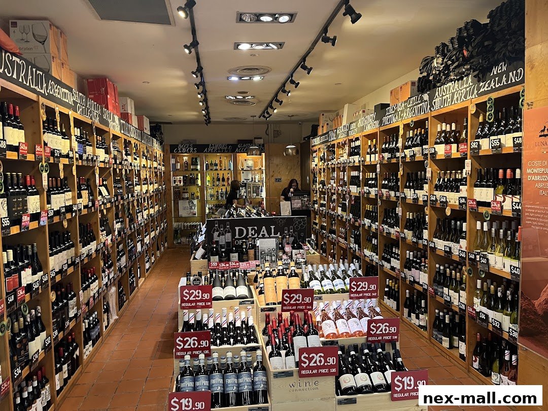 A well-stocked wine shop with shelves full of bottles from various countries and special offers displayed.