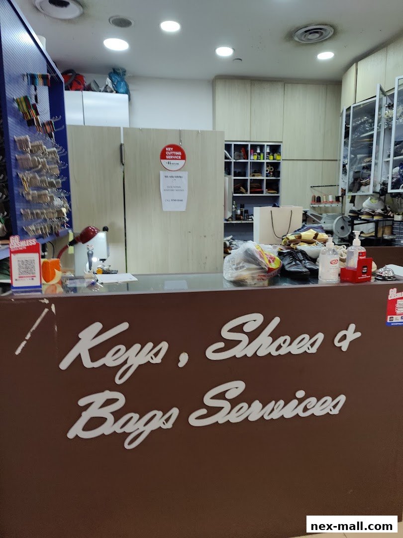 Interior of a shop offering key cutting, shoe, and bag services, with a counter and various tools.