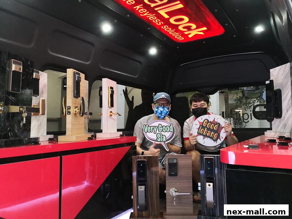 Two people are inside a van showcasing various digital door locks and handles.