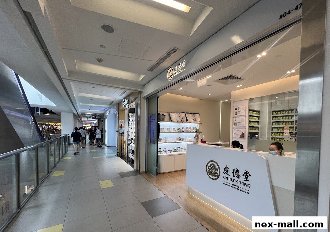The entrance of Kin Teck Tong TCM Clinic NEX, featuring a reception desk and shelves with products.