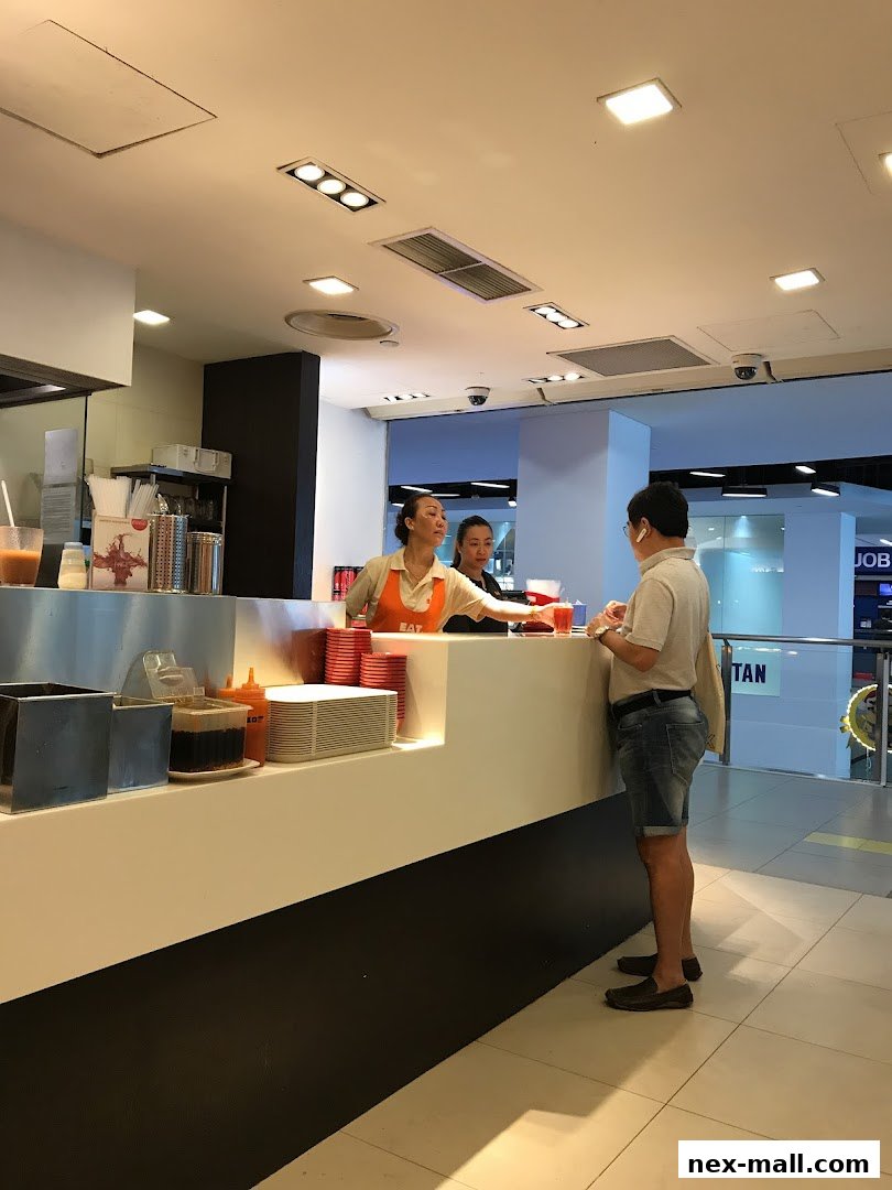 Staff serving a customer at the counter of the EAT shop.