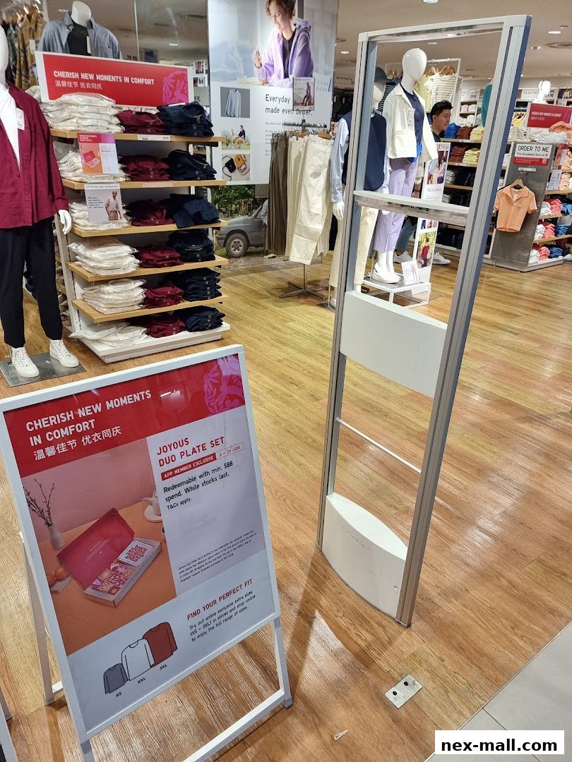 Interior view of a UNIQLO store with clothing displays and promotional signage.