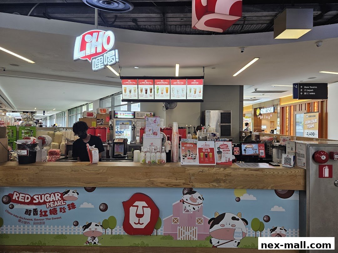 A LiHO TEA shop counter with a menu board and staff member serving customers.
