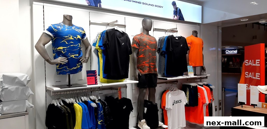 ASICS store display featuring mannequins in athletic wear and racks of shirts and shorts.