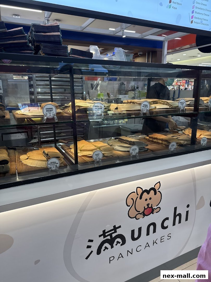 A display case filled with various pancakes and a counter with the shop's logo.