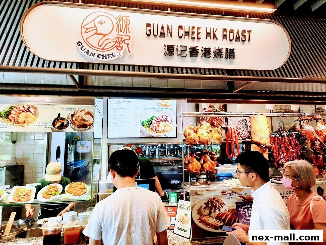 Customers ordering at a food stall featuring roasted meats like duck and chicken.