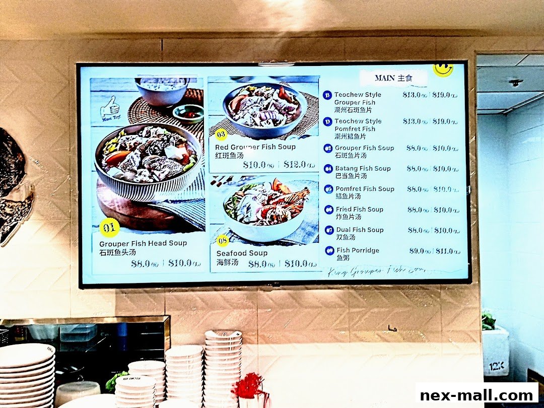 A digital menu board displaying various fish soup dishes and their prices.