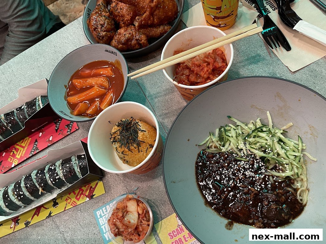 A spread of Korean dishes including fried chicken, tteokbokki, kimbap, and jjajangmyeon.