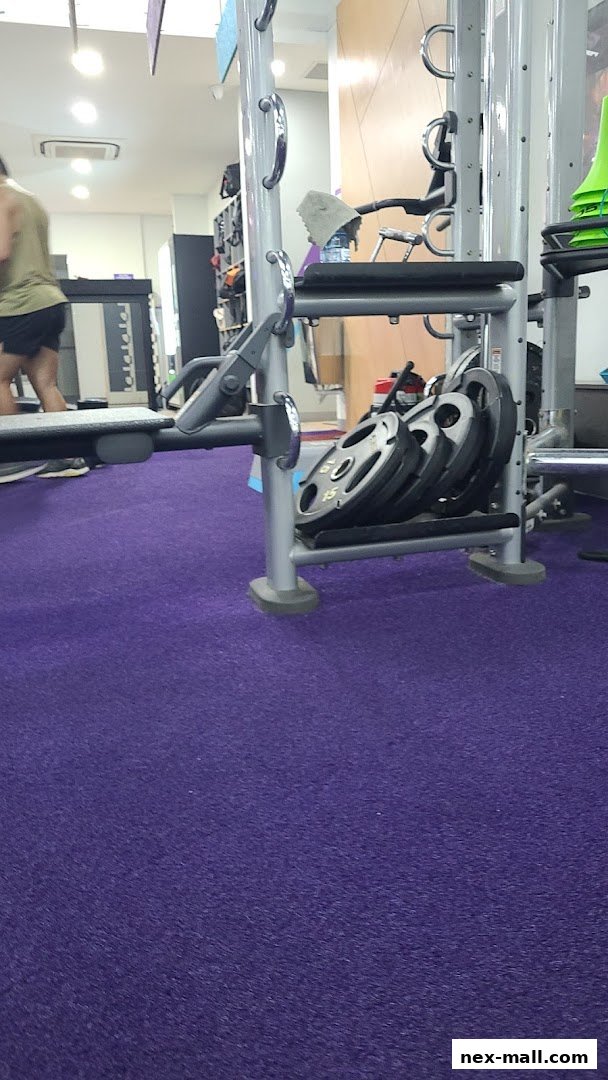 Interior view of a gym with weight plates stacked on a machine.