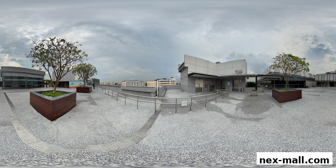 A panoramic view of the Serangoon Public Library's outdoor area with trees and seating.