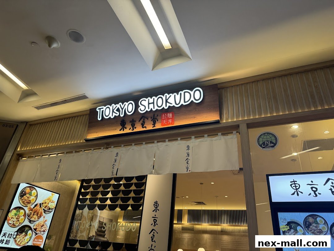 The exterior of Tokyo Shokudo, a Japanese restaurant, with its illuminated sign and menu displays.