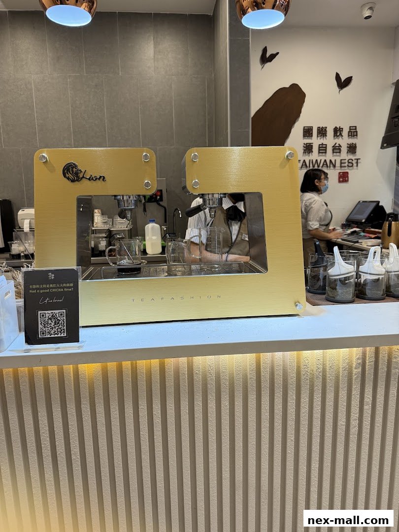 A modern tea shop counter with a golden espresso machine and staff preparing drinks.