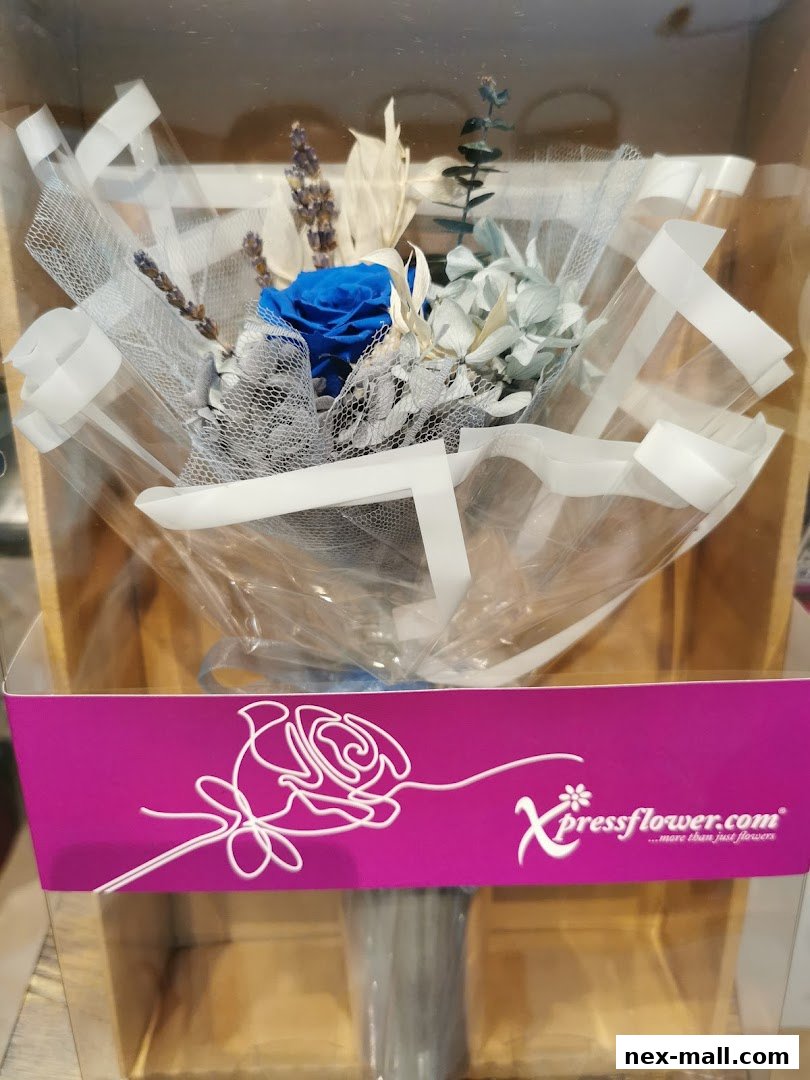 A beautifully arranged bouquet of preserved flowers in blue and light blue hues, presented in clear packaging.