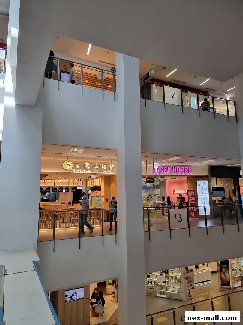 A multi-level mall interior with various shops and escalators visible.