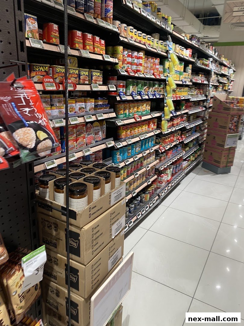 Aisle of canned goods and packaged food items in a supermarket.