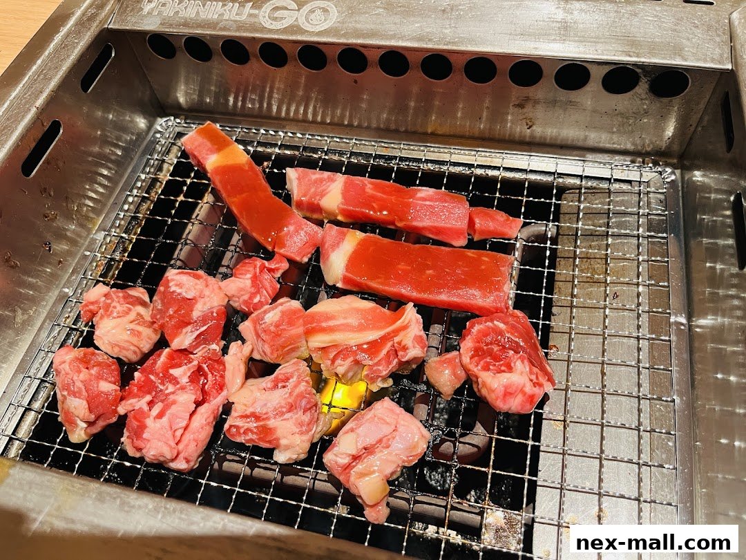 Fresh cuts of raw beef are arranged on a grill at Yakiniku-GO NEX.