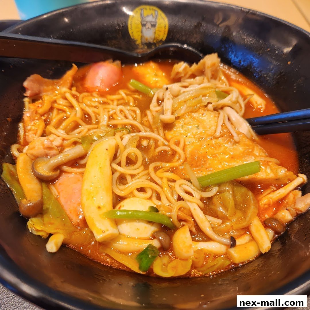 A close-up shot of a steaming bowl of Mala Tang with noodles, mushrooms, and vegetables.
