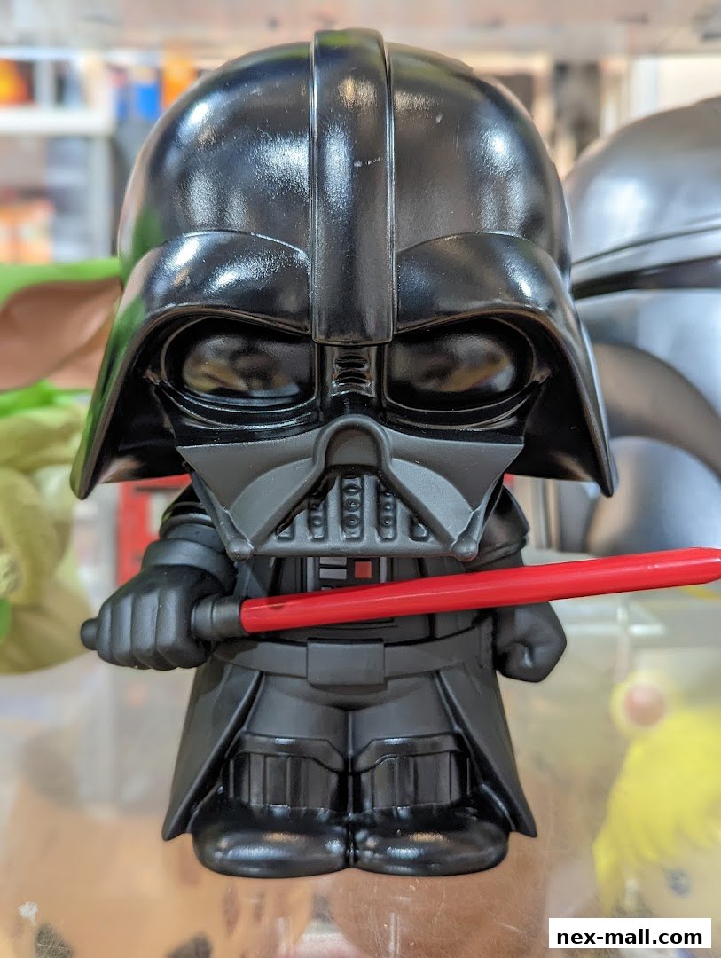 A close-up of a Darth Vader collectible figure holding a red lightsaber.