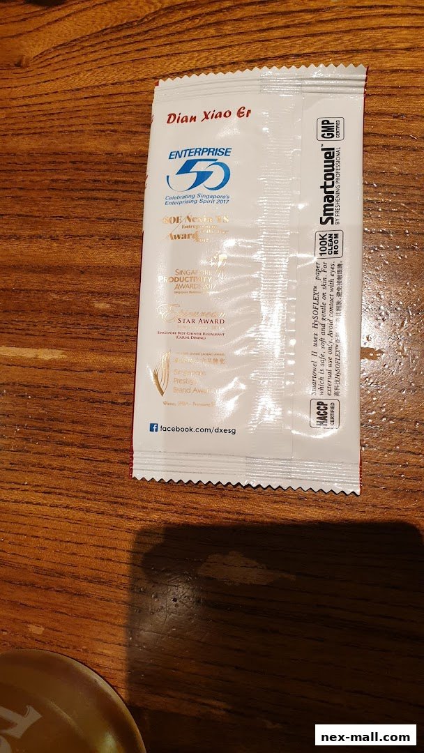 A wet wipe packet from Dian Xiao Er featuring various awards and certifications.