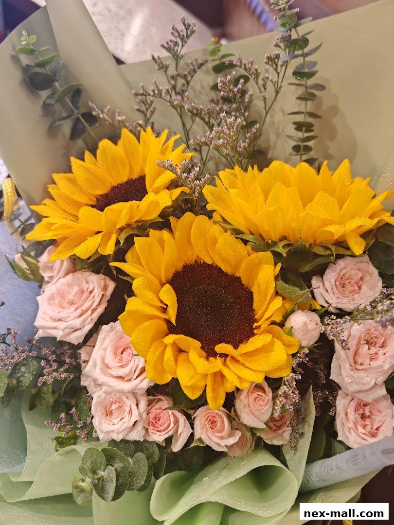 A vibrant bouquet featuring sunflowers, pink roses, and eucalyptus, artfully arranged.