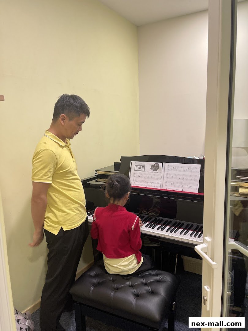 A teacher instructs a young student playing a piano in a music lesson.