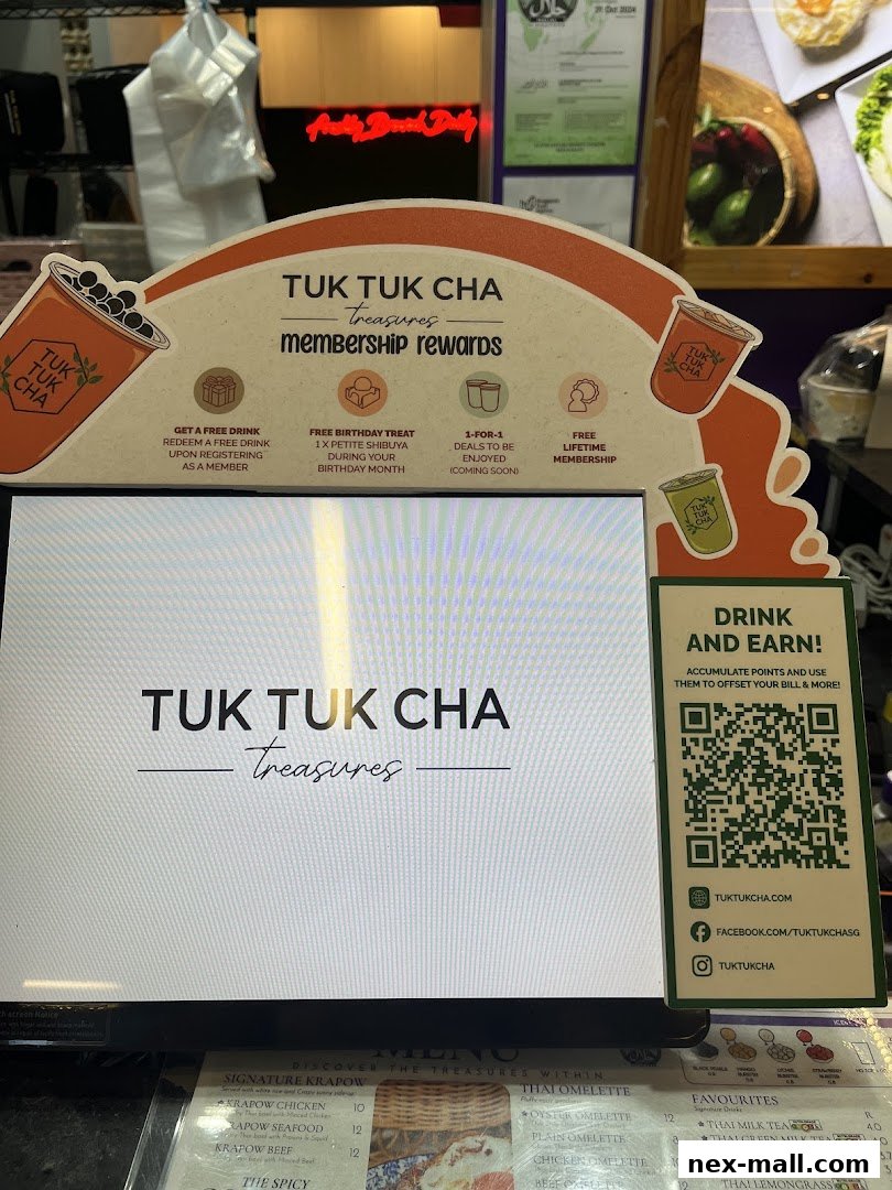 A display promoting Tuk Tuk Cha's membership rewards and a QR code for earning points.