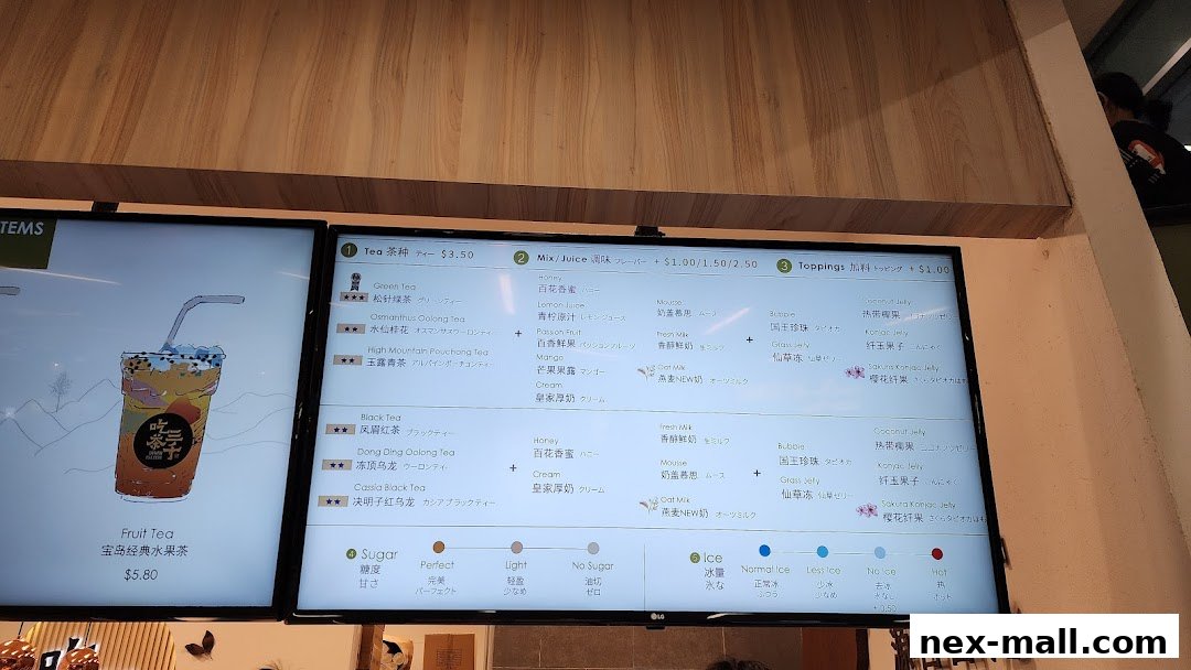 A digital menu board displaying various tea, juice, and topping options with prices.
