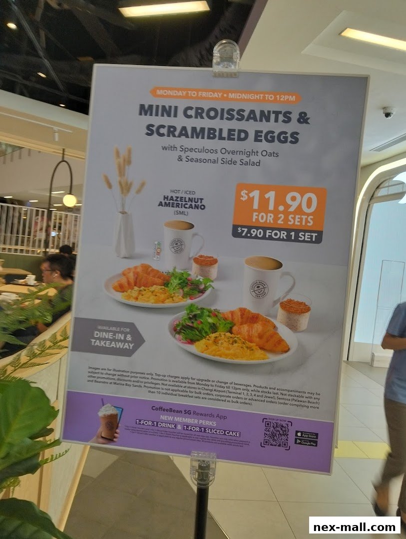 A promotional sign for The Coffee Bean & Tea Leaf featuring mini croissants and scrambled eggs.