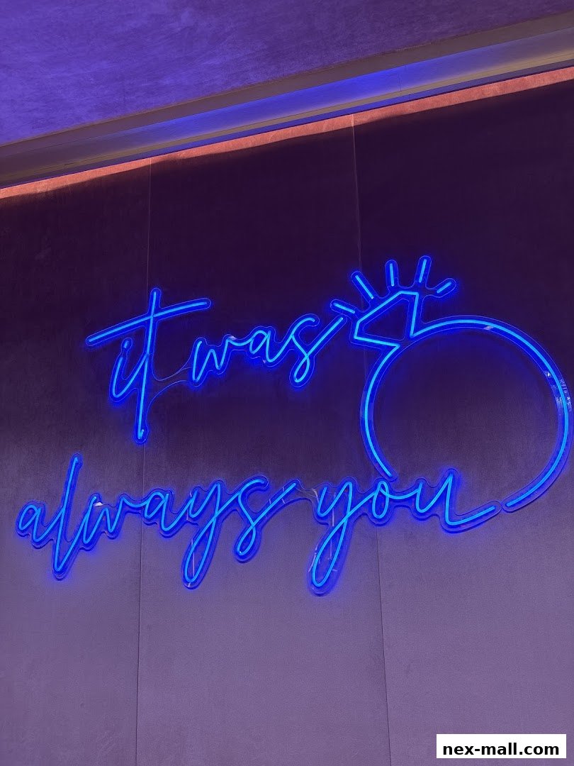 A blue neon sign with the text "it was always you" and a ring design.