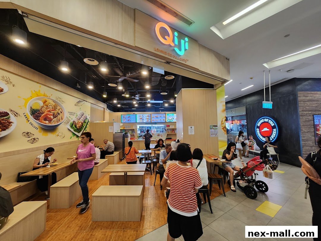 Interior view of a busy Qi Ji restaurant with customers dining and a Pizza Hut outlet visible in the background.