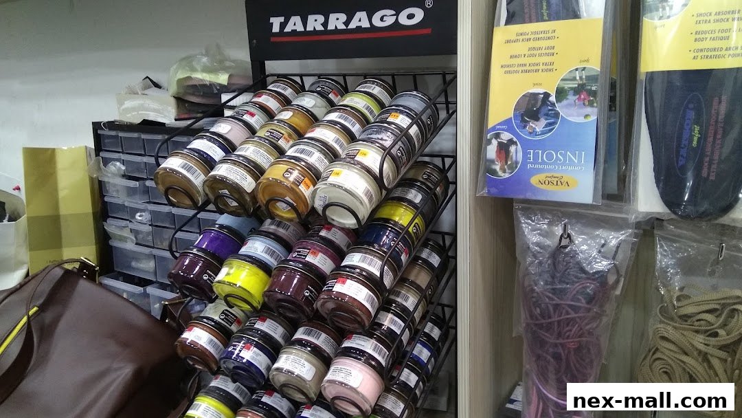 A display of shoe care products, insoles, and laces, with a brown handbag in the foreground.